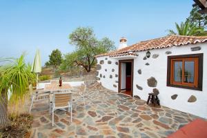 a house with a patio with a table and chairs at La Chirlaca in Tijarafe
