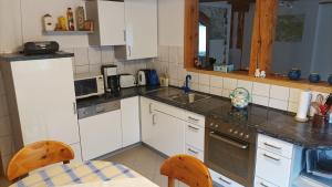 a kitchen with white cabinets and a sink and a table at Ferienwohnung Stell in Altenbrak