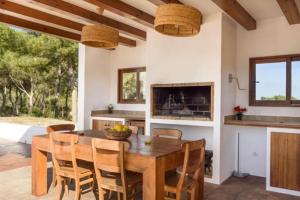 a kitchen and dining room with a wooden table and chairs at Villa Dalt S Era in Santa Gertrudis de Fruitera