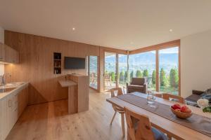 a kitchen and living room with a table and chairs at Moosbichlerhof in Marlengo
