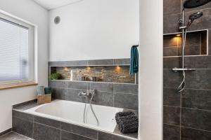 a bath tub in a bathroom with a window at Ferienhaus Lencer in Ühlingen-Birkendorf +26 photos