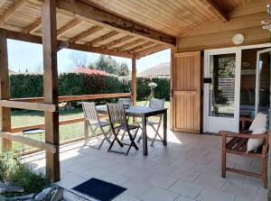 a patio with a wooden pergola and a table and chairs at La Petite Maison De Noémie in Gras