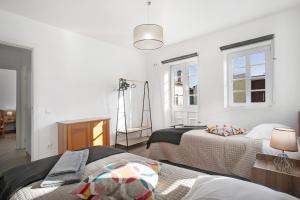 a white room with two beds and a mirror at Casa Davó in Leiria
