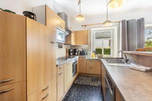 a large kitchen with wooden cabinets and a sink at Ferienhaus Rodershausen in Rodershausen