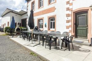 a table with chairs and an umbrella on a patio at Ferienhaus Rodershausen in Rodershausen