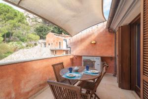 a patio with a table and chairs on a balcony at C 306 Attico Puntavilla Mare in La Maddalena
