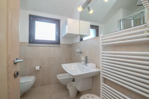 a white bathroom with a sink and a toilet at C 306 Attico Puntavilla Mare in La Maddalena +14 photos