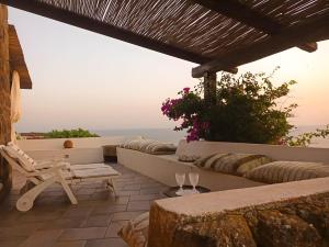a patio with a view of the ocean at Antico Dammuso Invernale in Pantelleria +14 photos