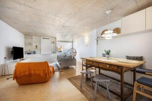 a living room with a dining room table and a kitchen at Olinda House in Odeceixe
