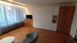 a living room with a blue chair and a sliding door at Appartement Arend in Dobel