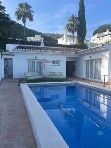 a swimming pool in front of a villa at Villa Gracia in Mijas