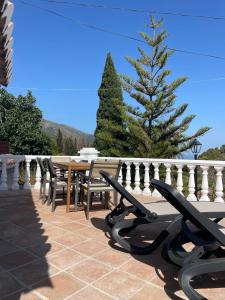 a table and chairs on a patio with a christmas tree at Villa Gracia in Mijas