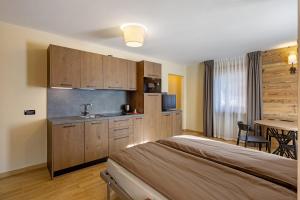 a bedroom with a bed and a kitchen with a table at Villa Elma - Livigno in Livigno +31 photos