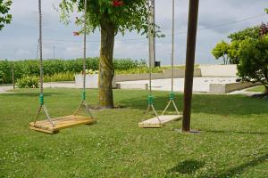 two swings in a park with a tree at Chambre d'hôtes La Champagne in Sémussac