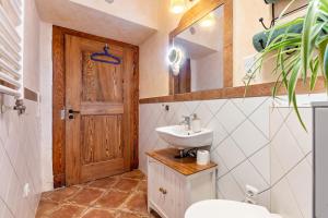 a bathroom with a sink and a wooden door at Apartment zur alten Post in Ulrichstein +13 photos