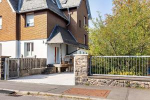 a brick house with a gate and a fence at Apartment zur alten Post in Ulrichstein