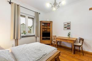a bedroom with a bed and a desk and a table at Apartment zur alten Post in Ulrichstein