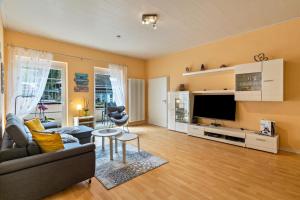 a living room with a couch and a tv at Ferienhaus Brigitte in Hornberg