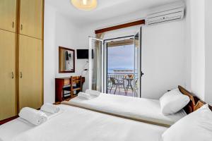 two beds in a bedroom with a view of the ocean at Panorama apartment 2 in Póndi