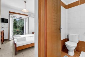 a bathroom with a bed and a toilet and a window at Panorama apartment 2 in Póndi +26 photos