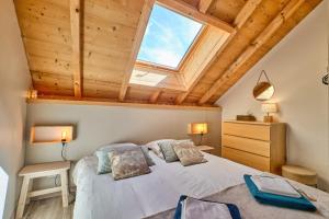 a bedroom with a large bed with a skylight at Duplex Sauna privé Vénosc Le 1618 in Les Deux Alpes