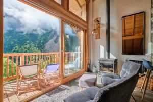 a room with a balcony with chairs and a fireplace at Duplex Sauna privé Vénosc Le 1618 in Les Deux Alpes