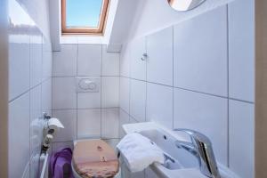 a white bathroom with a sink and a toilet at Seehaus Juist in Juist +20 photos