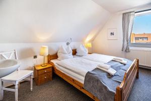 a bedroom with a large bed and a sink at Seehaus Juist in Juist