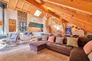 a living room with a brown couch and a kitchen at Duplex Sauna privé Vénosc Le 1618 in Les Deux Alpes