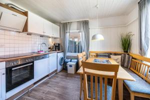 a kitchen and dining room with a table and chairs at Seehaus Juist in Juist