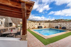 a backyard with a swimming pool and a patio with a table at Casa Elvira in Chimiche