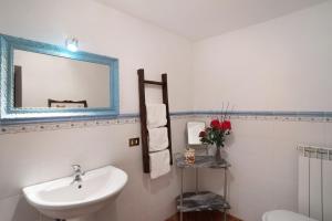 a white bathroom with a sink and a mirror at Antico Granaio in Vessalico +14 photos