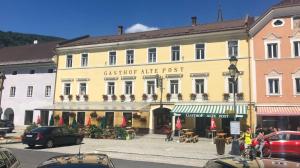a large yellow building with a cafe in front of it at Gh Alte Post - Top 4 Commodore in Gmünd in Kärnten