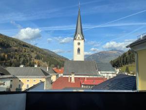 a church with a steeple and a clock tower at Gh Alte Post - Top 4 Commodore in Gmünd in Kärnten +3 photos