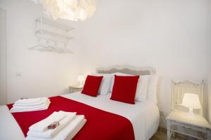 a bedroom with a large bed with red and white pillows at Páteo da Várzea 5 in Colares
