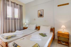 two twin beds in a room with a window at Studio Phaethon in Póndi