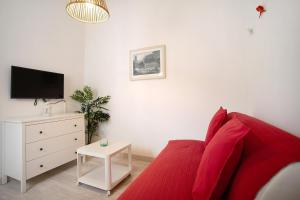 a living room with a red couch and a tv at Páteo da Várzea 5 in Colares