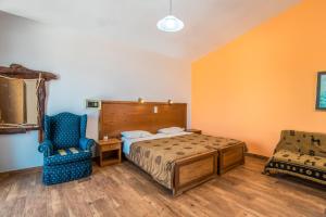 a bedroom with a bed and a blue chair at Mirage Arillas Honeymoon Studio in Arillas