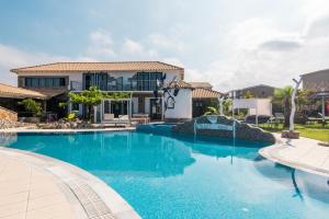 a swimming pool in front of a house at Mirage Arillas Honeymoon Studio in Arillas