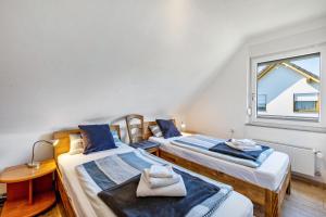 two beds in a room with a window at Ferienwohnung im Elsetal in Plettenberg