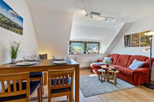 a living room with a red couch and a table at Ferienwohnung im Elsetal in Plettenberg
