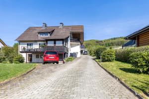 a red truck parked in front of a house at Ferienwohnung im Elsetal in Plettenberg