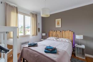 a bedroom with a bed with two towels on it at Maloan, gite avec piscine in Saint-Julien-de-Lampon +17 photos