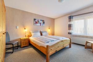 a bedroom with a large bed and a chair at Ferienwohnung Sawade Schafstedt in Schafstedt