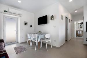 a dining room with a table and white chairs at Ninho do Rei in Fátima