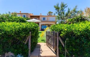 a house with a fence and an umbrella at Embat in Colonia de Sant Pere
