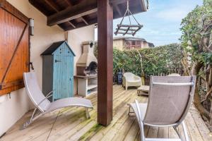 a patio with two chairs and a wood stove at Maisonnette Biscarosse in Biscarrosse