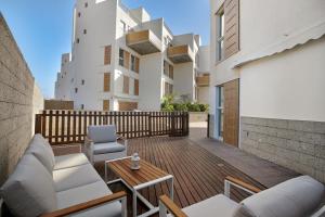 a patio with a couch and chairs on a wooden deck at Los Martínez Duplex in El Médano