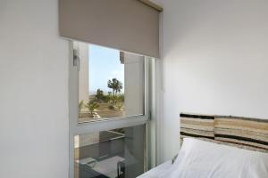 a bedroom with a window with a view of the beach at Los Martínez Duplex in El Médano +22 photos