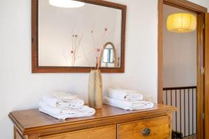 a wooden dresser with a mirror and towels on it at Casa Mia Jacuzzi Exterior in Ronda +18 photos